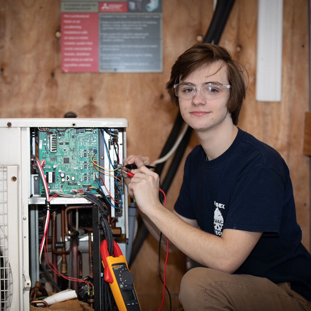 A student soldering wires on an motherboard.