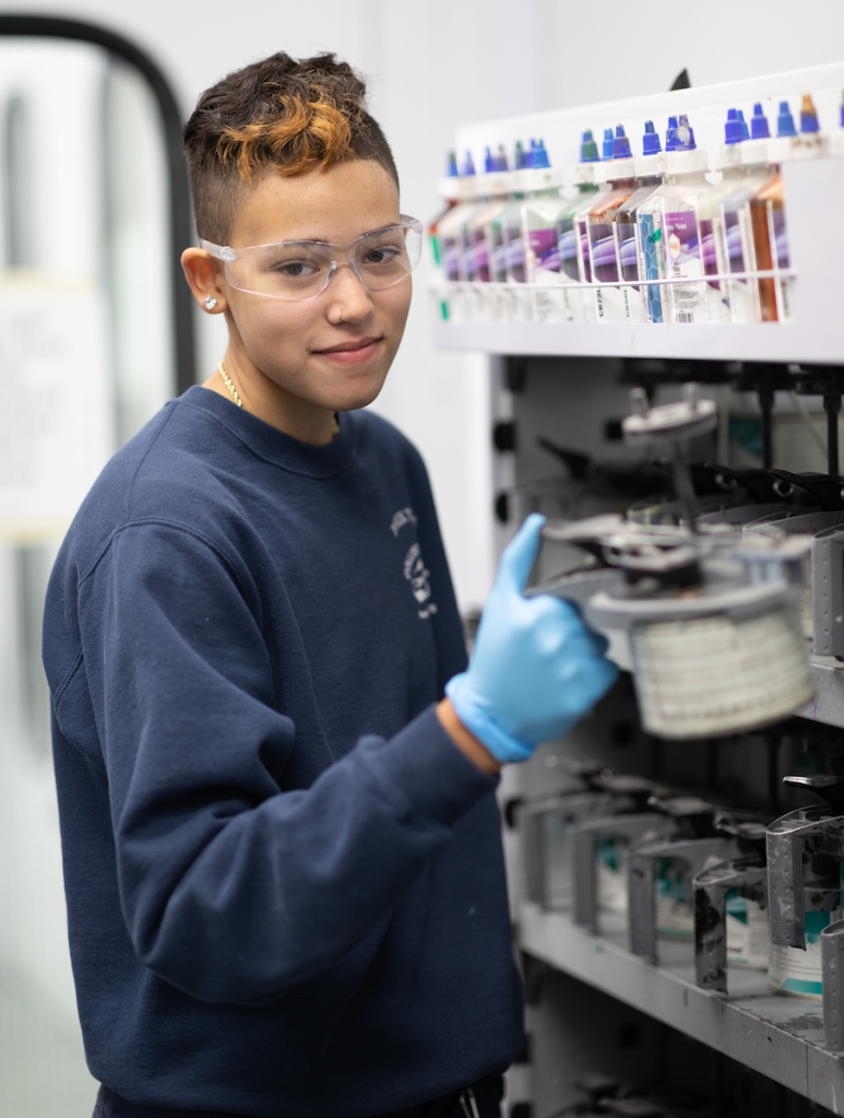 Student preparing automotive paint for application. 