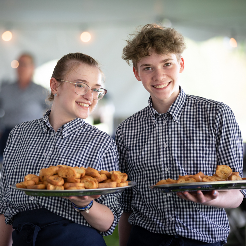 Students passing hors d'oeuvres.